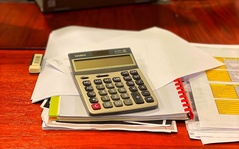 calculator laying on messy pile of papers