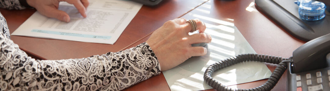 Arm of a woman using a computer mouse.